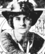 A black-and-white photograph of a woman in a boater-style hat