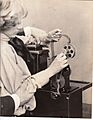 Publicity shot, girl threading film through Edison home projecting kinetoscope. (ac20658b-ca45-4073-88fb-ecae61841eea)