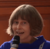 A woman with a bob haircut talking into a microphone