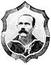 Head of a man with close cropped hair and a bushy mustache wearing a sailor suit with a wide flat collar and a scarf tied around the neck. A shield-shaped frame is drawn around the man's portrait.
