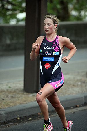 Women in black and pink running onepiece, and red and white trainers