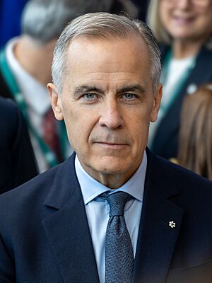 Head shot of Carney wearing a suit and tie