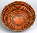 A color picture of an orange ceramic bowl