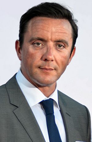 Serafinowicz smiling and wearing a grey suit
