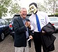 U.S. Congressman Dana Rohrabacher shakes hands with a supporter wearing Guy Fawkes mask