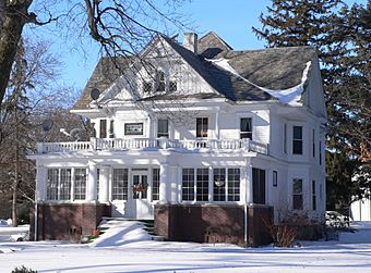 Large two-story cross-gabled house in snow