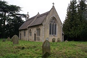A simple stone church seen from the southeast, showing the chancel and the nave with a bellcote at the far end