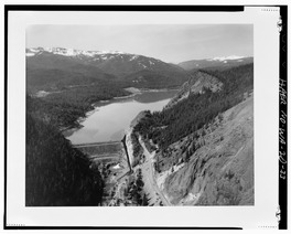 AERIAL VIEW OF TIETON STORAGE DAM AND RIMROCK LAKE (View of downstream face, spillway at center of photo, outlet works in operation.) - Tieton Dam, South and East of State HAER WASH,39-NACH.V,2-33.tif