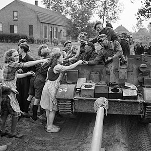 A carrier crew of 8th Rifle Brigade hands out chocolate to Dutch civilians during the advance of 11th Armoured Division in Holland, 22 September 1944. B10245