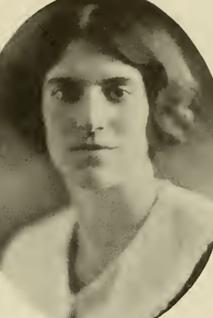A yearbook photograph of a young white woman with short dark hair and dark eyes