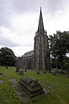 A large Gothic Revival church with an elaborate west tower surmounted by a spire supported by flying buttresses