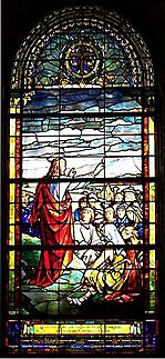 Christ standing on mountain, stretches his arm towards the  people gathered to hear Him speak.