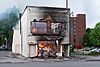 A man walks by a burning building on Thursday morning after a night of protests and rioting in Minneapolis, Minnesota (49945327763).jpg