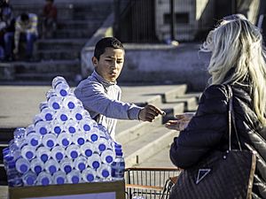 Street transaction between boy selling water bottles and woman, Istanbul (13271945715)