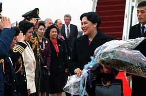Sirikit Kitiyakara, the queen of Thailand, smiles as she meets officials gathered to greet her upon her arrival on base