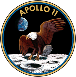 Circular insignia: eagle with wings outstretched holds olive branch on Moon with Earth in background, in blue and gold border.