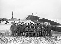 Personnel of 'B' Flight, No. 409 Squadron RCAF, pose for a formal portrait with one of their Beaufighter Mk IIs at Acklington, January 1942. CH4903.jpg