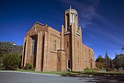 Image of side of church, brick construction with bell tower in foreground