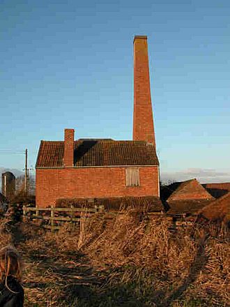 Red brick industrial building with tall chimney.