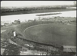 Aerial view of Albert Park Lake and the South Melbourne Cricket Ground in the foreground with a football match in progress