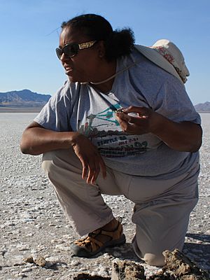 A photo of Dr. Kennda Lynch in the field, examining materials in an ancient lake bed