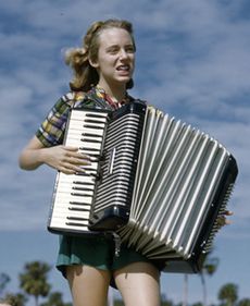 Lois Duncan Steinmetz playing the accordion aboard the shantyboat Lazy Bones (alt crop)