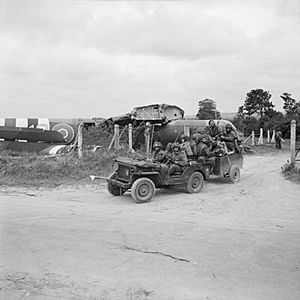 Riflemen aboard a jeep and trailer