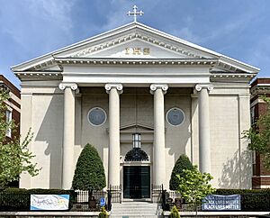 A white Neoclassical religious building in a residential neighborhood