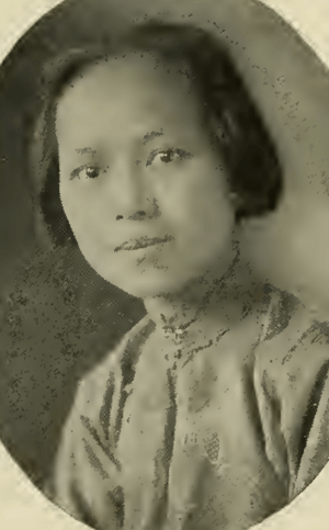 A young Chinese woman, dark hair cropped to jaw length, wearing a high-collared loose-fitting blouse or dress