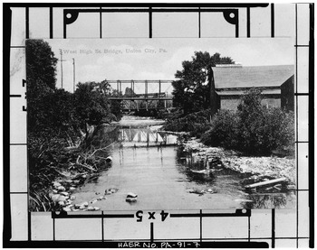 Photocopy of photograph, date unknown. VIEW OF WEST HIGH STREET BRIDGE OVER SOUTH BRANCH OF FRENCH CREEK, WITH PENN RAILROAD BRIDGE IN BACKGROUND. (Original in Union City HAER PA,25-UNCI,2-7.tif
