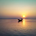 Silhouette of a fisherman on boat during sunset at Brahmaputra River, Assam, India