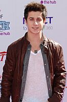 David Henrie smiling in a leather jacket.