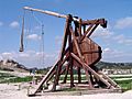 A tall wooden structure with a throwing arm counterbalanced by a large weight
