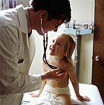 Doctor uses a stethoscope to examine a young patient