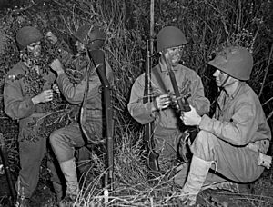 Four Marines hide and camouflage themselves in the brush during a training exercise, Camp Pendleton, circa 1943 (cropped)