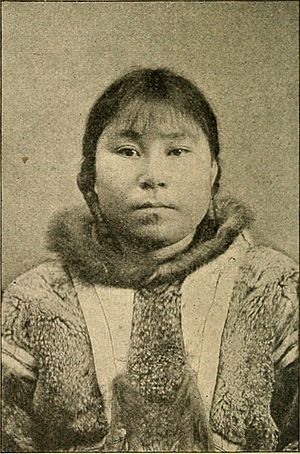 Young Alaska Native woman, wearing braids and fur garment