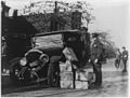 Policeman and wrecked car and cases of moonshine