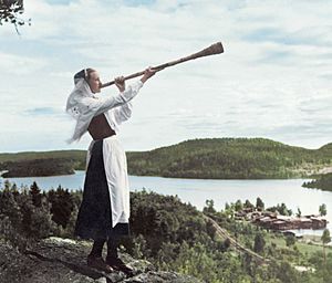 A young Swedish women playing a birch trumpet around 1930 (cropped)