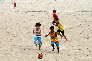 Crianças jogando futebol de areia