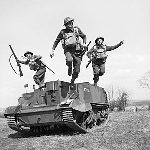 Troops of the 2nd Monmouthshire Regiment leap from their Universal carrier during an exercise near Newry in Northern Ireland, 26 April 1941. H9234