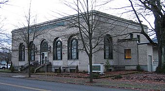 Photograph of the St. Johns Station, a rectangular, single-story building on its own block with tall, arched windows