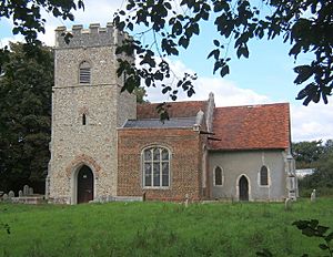 A church seen from the south with a flint battlemented tower on the left, a brick chapel in the middle, and a rendered chancel to the right