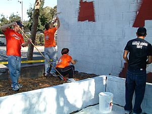 US Navy 061009-N-6699H-003 Strike Fighter Squadron Eight One (VFA-81) Commanding Officer, Cmdr. Mike Boyle, and his wife (center) lead a painting crew at the East Oakland Youth Development Center
