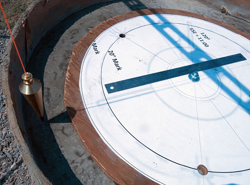 Wooded Jig being aligned with the sun using a plumb bob