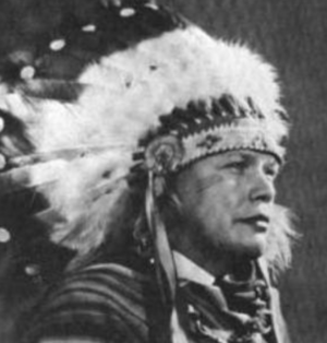 A Native American man wearing a feathered headdress