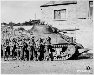 Yanks of 60th Infantry Regiment advance into a Belgian town under the protection of a heavy tank. - NARA - 531213