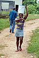 Young woman carrying a water bucket on her head, Clarendon, Jamaica