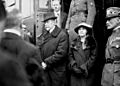 A serious-looking Masaryk and his daughter getting off a train, surrounded by people