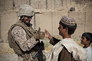 U.S. Marine Corps Cpl. Abraham Porath, left, assigned to Combined Anti-Armor Team 1, 3rd Battalion, 4th Marine Regiment, thumb wrestles with an Afghan boy during a joint vehicle checkpoint with Afghan National 130527-M-TQ917-077