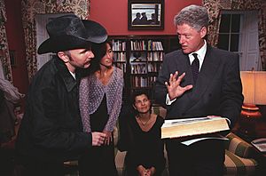 President Bill Clinton and musician the Edge look at a book